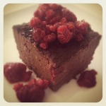 Photo of slice of brownie topped with raspberries